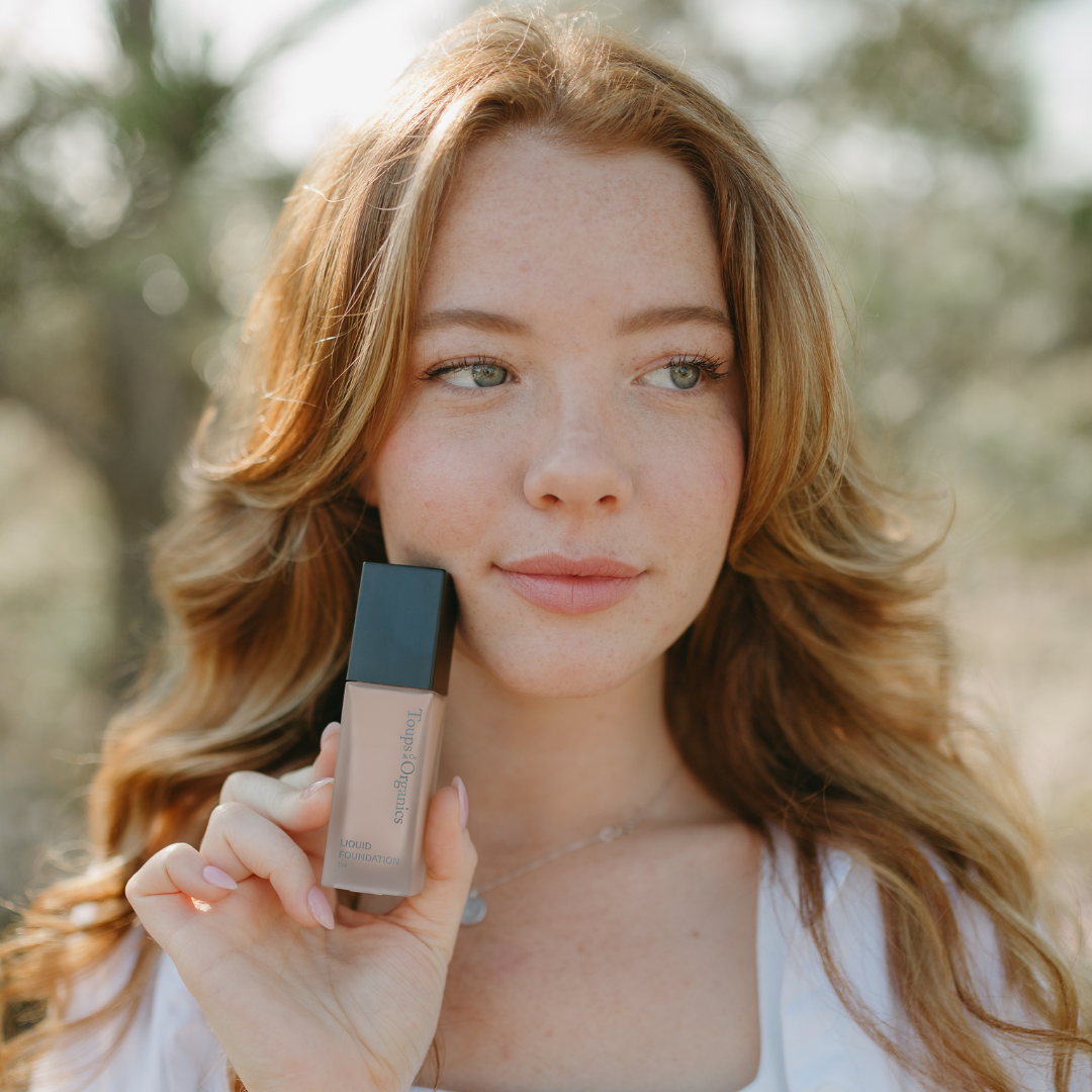 young-woman-holds-up-a-bottle-of-nontoxic-foundation