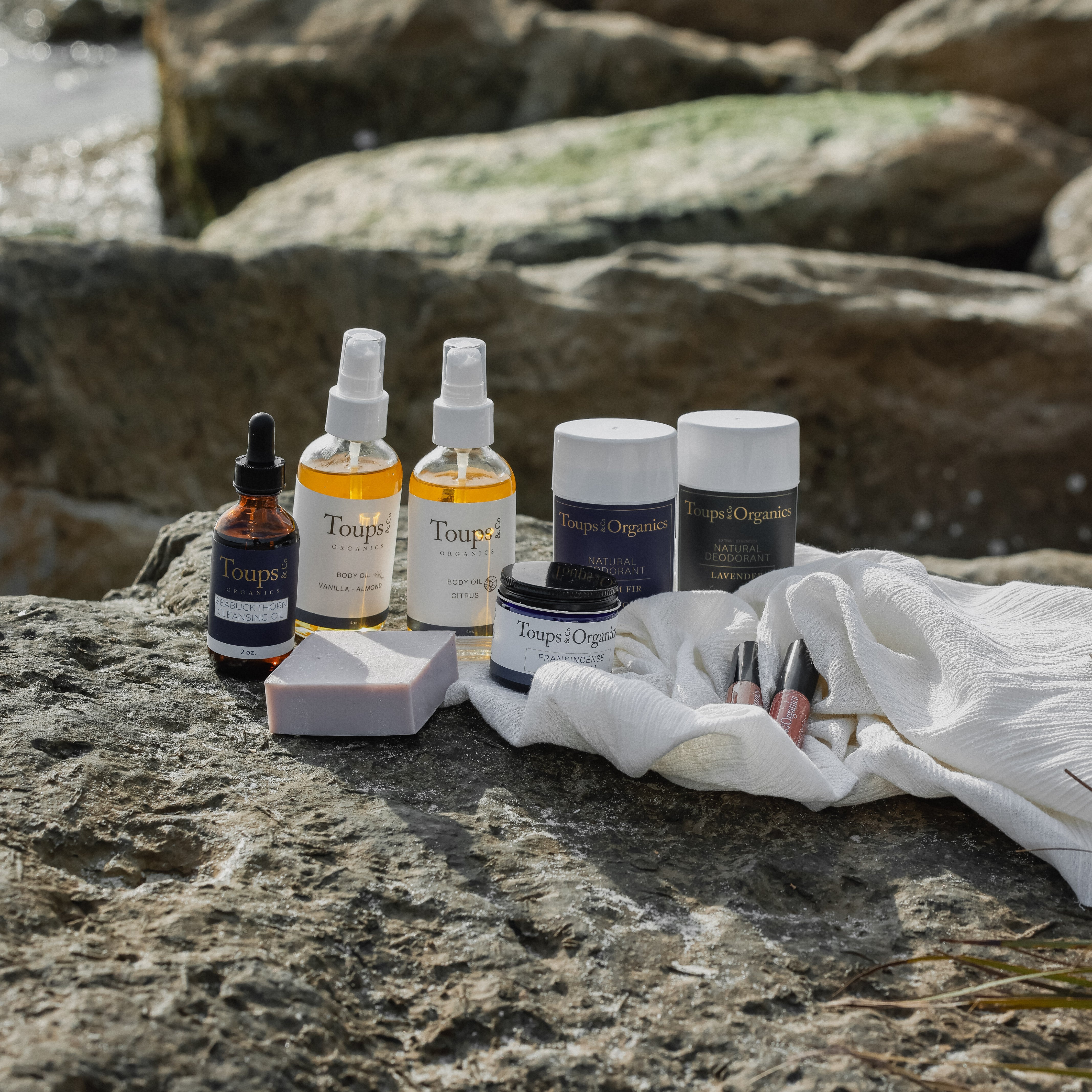 organic-body-oil-and-natural-deodorant-displayed-at-the-beach