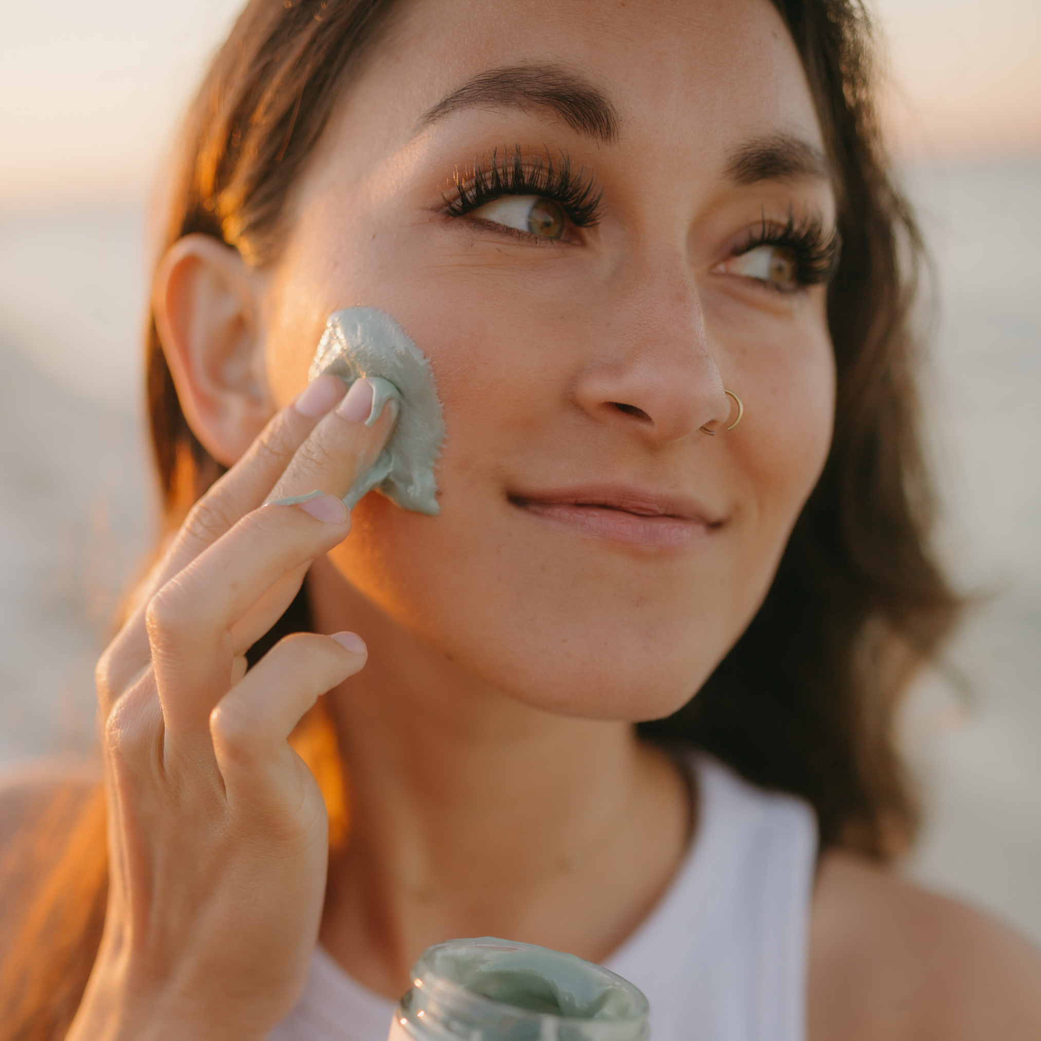 young-woman-applying-a-raw-honey-face-mask-to-her-cheek