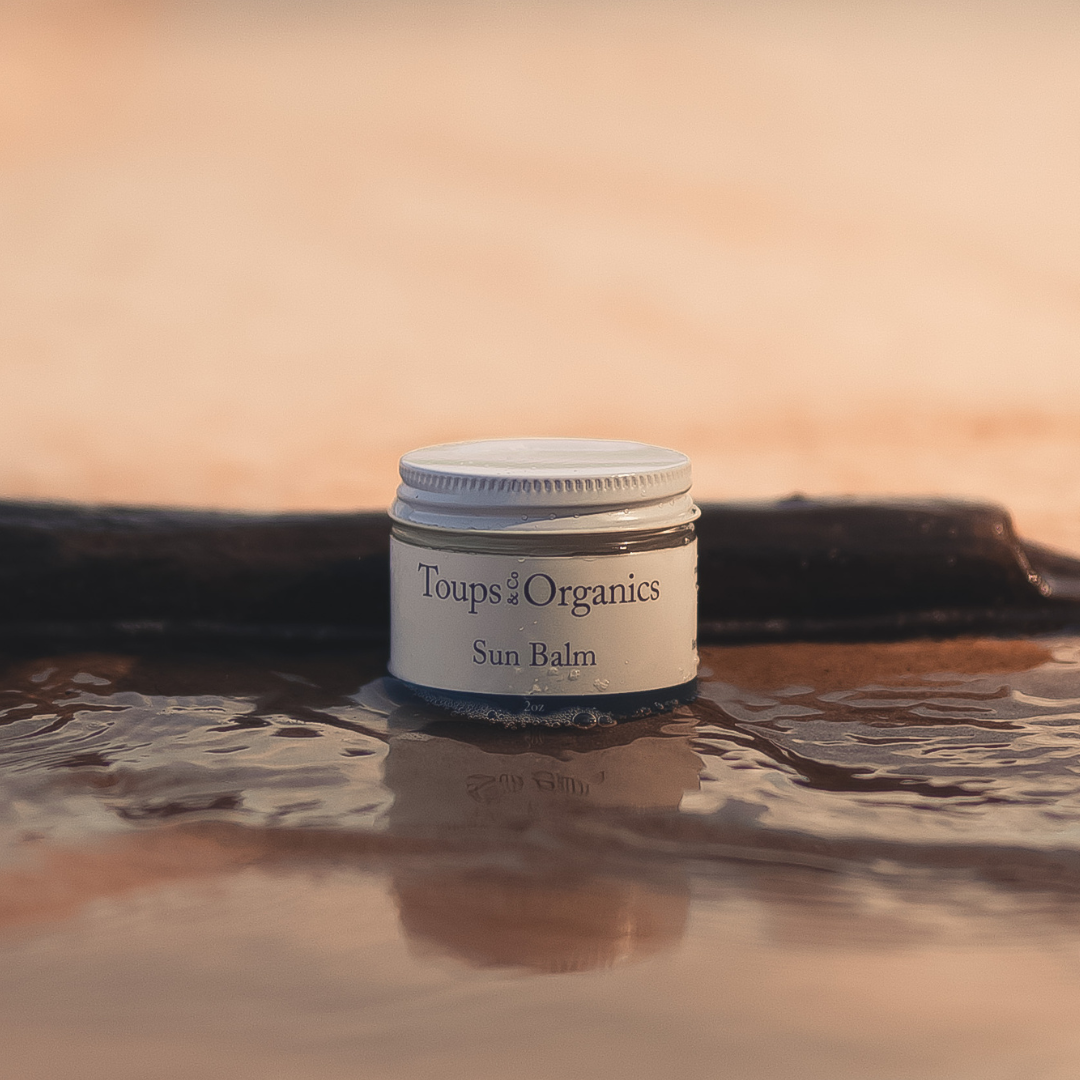 beef-tallow-sunscreen-bottle-sits-on-the-beach