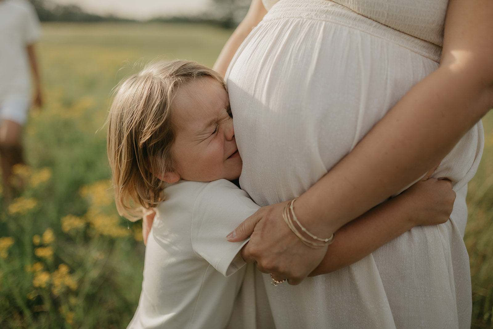 young-child-hugs-his-pregnant-moms-belly