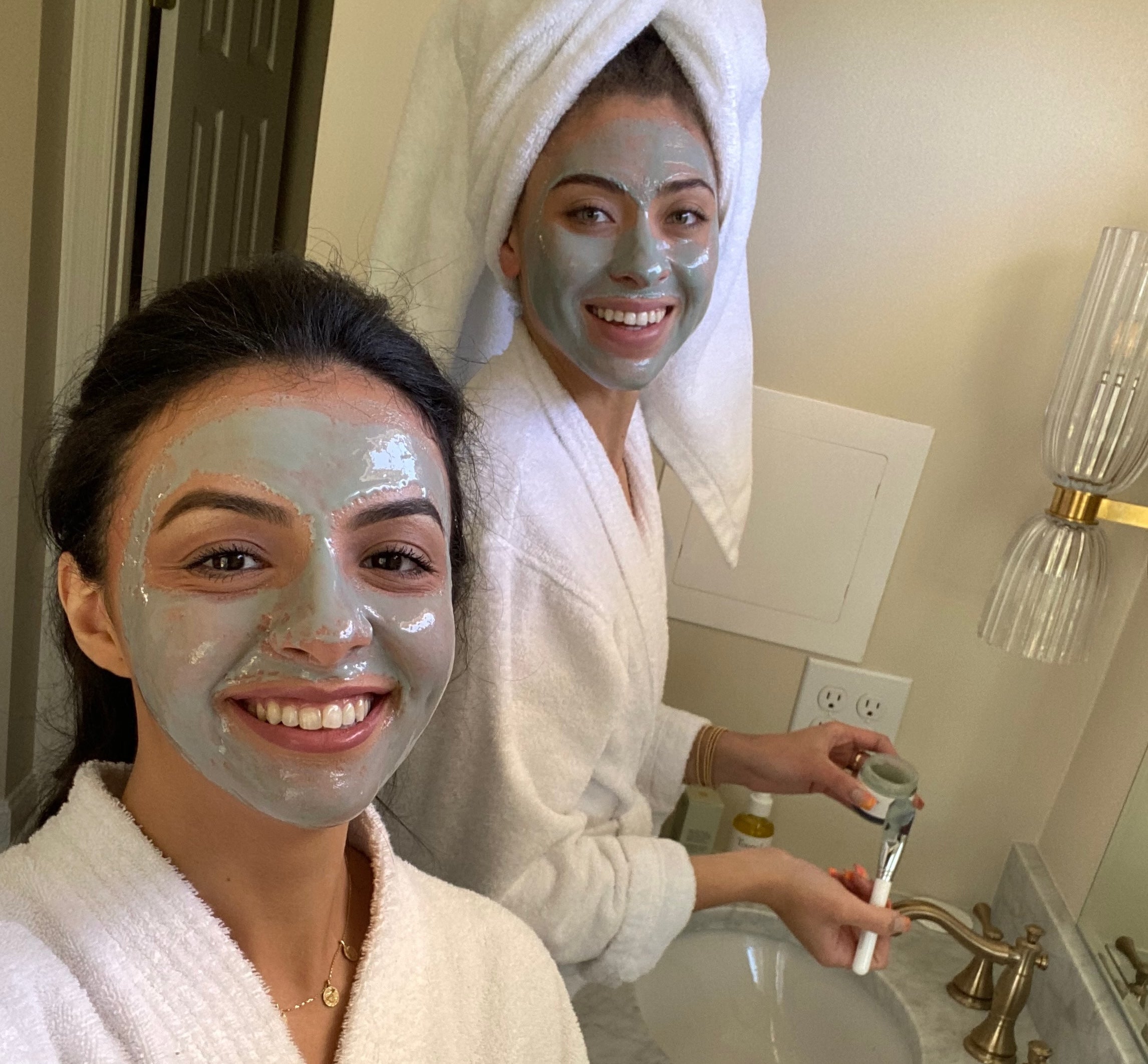 Teen girls enjoying a self-care night with natural clay mask and skincare brush, part of a non-toxic back-to-school beauty routine.