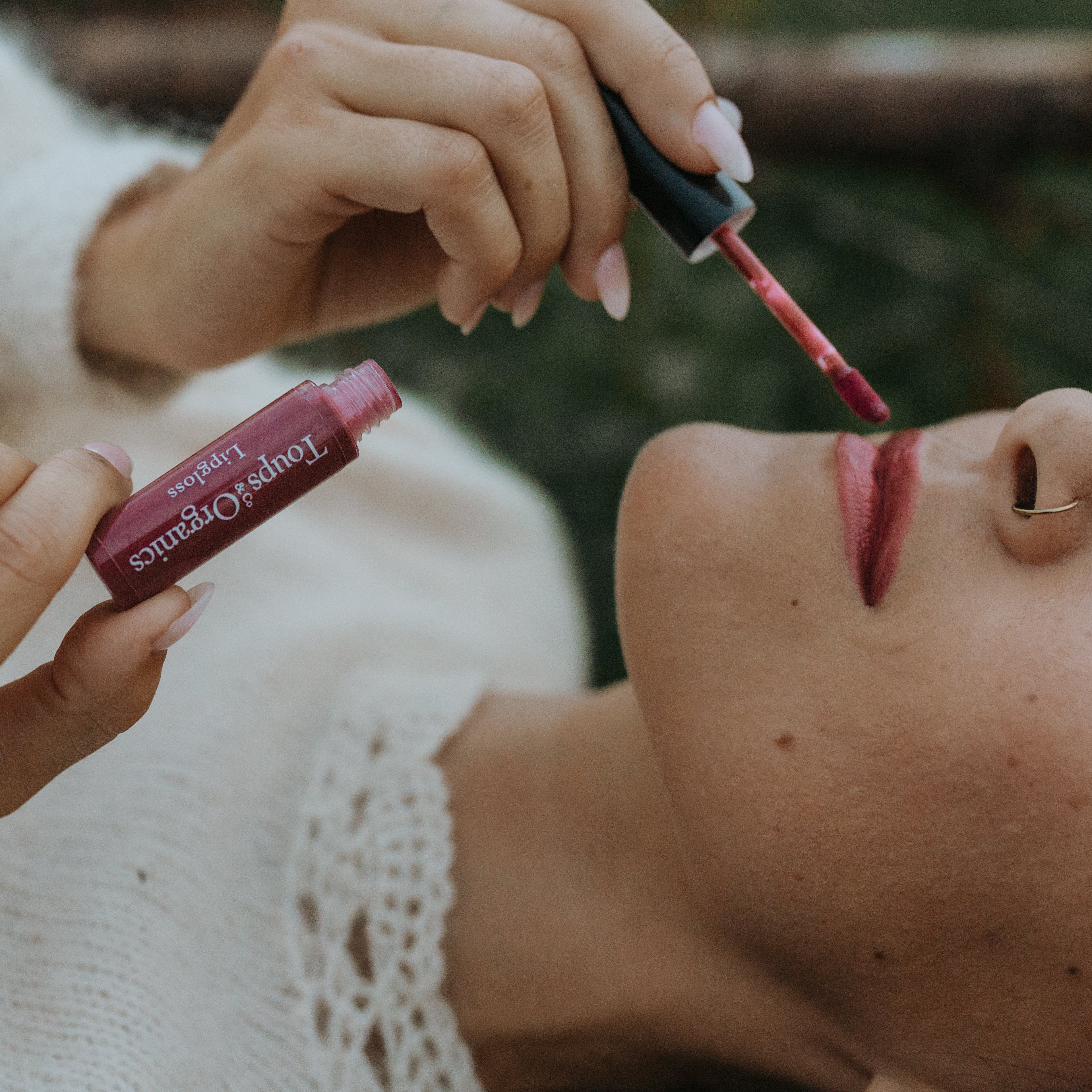 woman-applies-dark-shade-of-organic-lip-gloss-to-her-lips