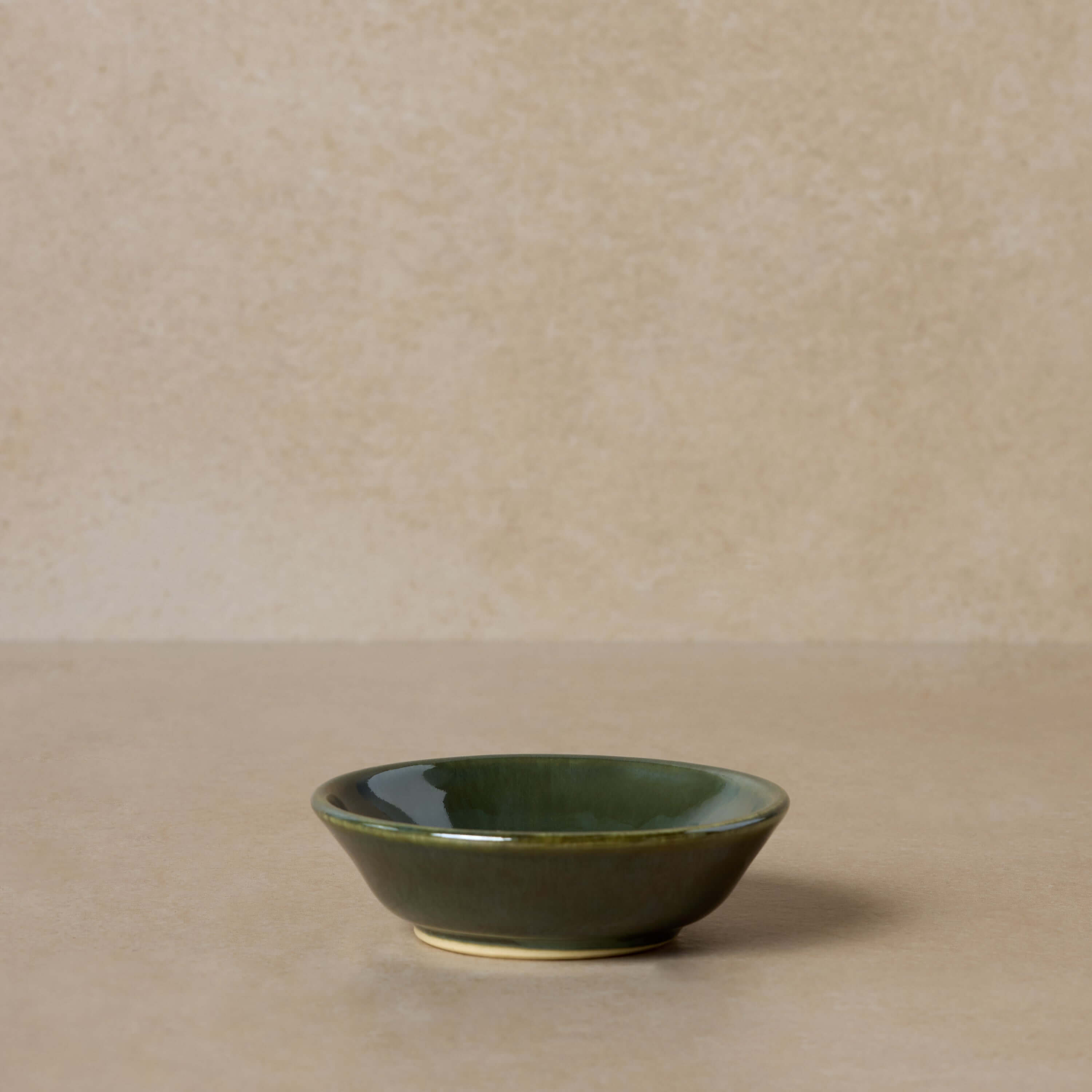 green-pottery-bowl-for-mixing-face-masks-displayed-on-brown-background