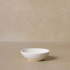 white-pottery-bowl-for-mixing-face-masks-displayed-on-brown-background