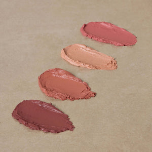 four-swatches-of-nontoxic-cream-blush-on-brown-surface