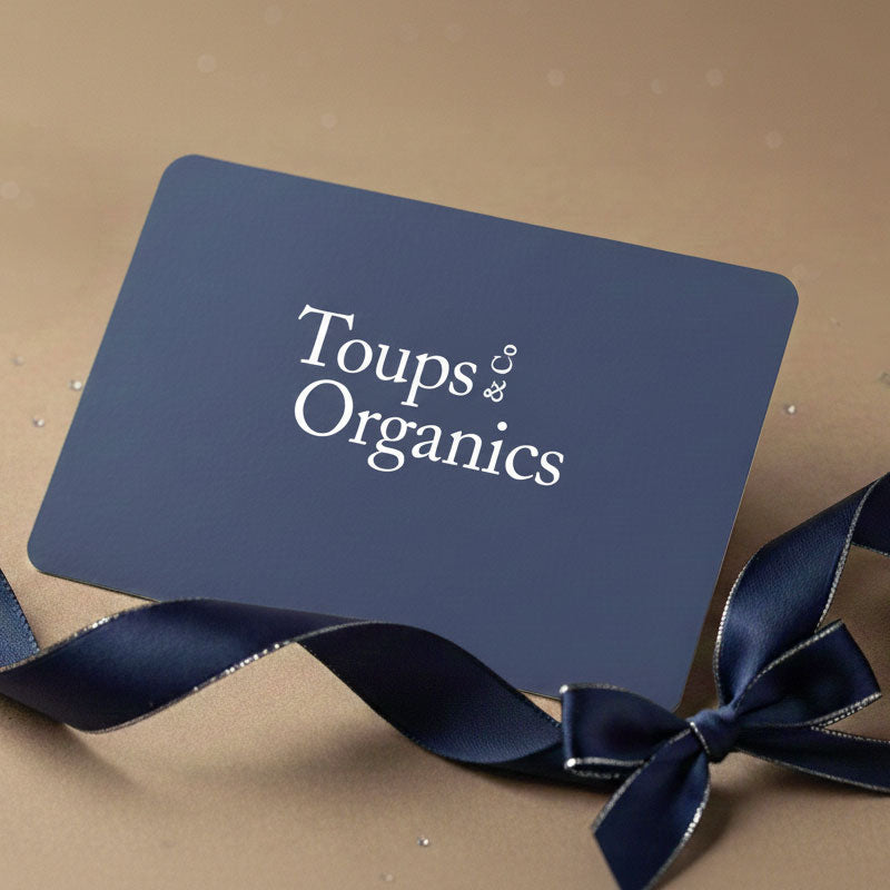 A navy blue Gift Card from Toups and Co Organics, featuring white text and rounded corners, is paired with a matching navy ribbon bow.