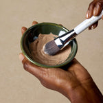 woman-stirs-detox-mask-with-mask-applicator-brush