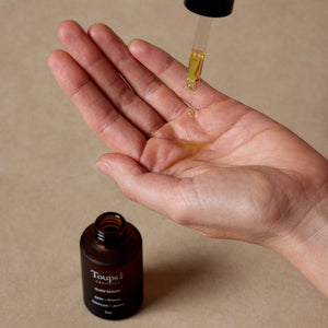 woman-drips-brightening-serum-into-her-hands