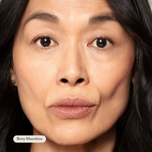 Close-up of a woman with natural makeup and neutral expression wearing Toups and Co Organics Organic Lip Gloss in Berry Mauvelous, a moisturizing, safe, and nontoxic mauve shade.