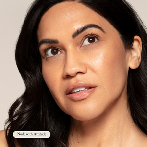 A woman with medium skin and dark hair looks upward, wearing Toups and Co Organics Organic Lip Gloss—a safe, nontoxic, moisturizing formula in a glossy nude shade.
