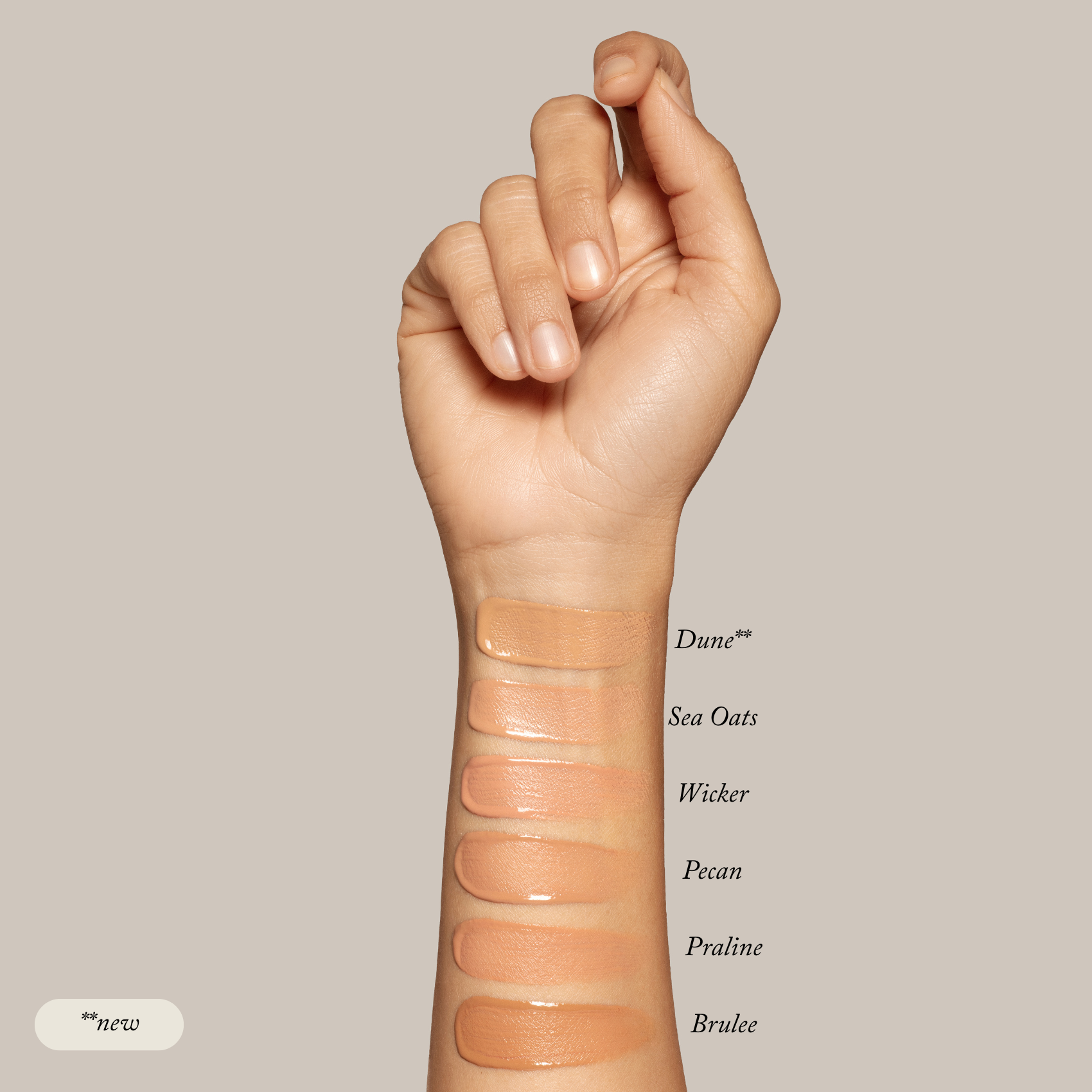 A hand displays six Toups and Co Organics Liquid Foundation swatches—Dune (new), Sea Oats, Wicker, Pecan, Praline, Brulee—on the inner forearm for a natural glow on sensitive skin, set against a neutral background.