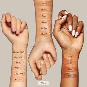 Three arms with varying skin tones display Toups and Co Organics Liquid Foundation swatches from light to dark on a neutral background, showcasing shade options for a natural glow.