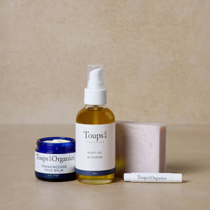 nontoxic-skincare-gift-set-with-blossom-body-oil-displayed-against-brown-background
