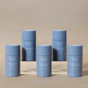 Five blue cylindrical containers of Toups and Co Organics Natural Deodorant, each scent unique, are displayed on a neutral background—highlighting natural deodorant perfect for sensitive skin.