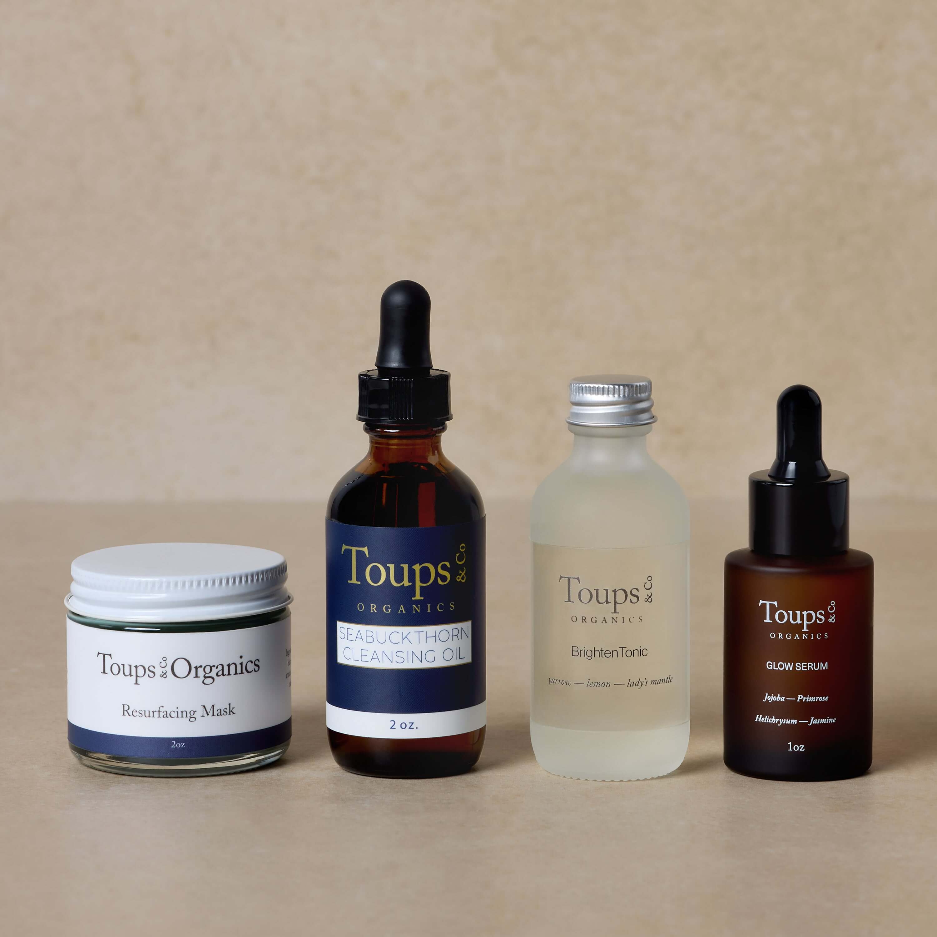 Toups and Co Organics’ Skincare Starter Set, featuring four nontoxic essentials, is displayed in a row against a neutral background—your perfect introduction to natural skincare.