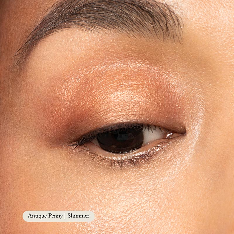 A close-up of a closed eye with Toups and Co Organics Natural Eyeshadow Singles in shimmery copper shade applied to the lid, highlighting its rich pigmentation.