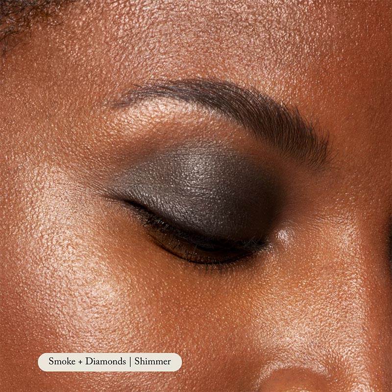 Close-up of a closed eye wearing Toups and Co Organics Natural Eyeshadow Singles in smooth, dark grey shimmer. The even, moisturized skin highlights the rich pigmentation for a striking effect.