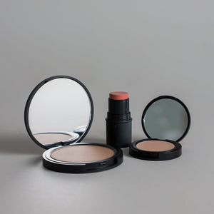 Toups & Co bronzer, cheek tint, and concealer photographed together on a clean grey seamless background, showcasing a versatile collection of complexion and cheek makeup essentials.