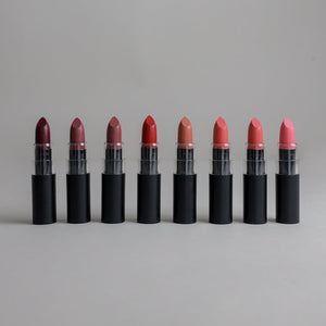 Eight shades of non-toxic lipstick lined up from berry to pink