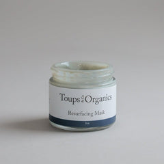 A 2 oz open jar of Toups and Co Organics Resurfacing Mask, formulated with anti-aging blue algae extract, is displayed against a simple light background.