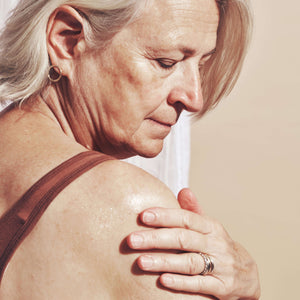 woman-applies-organic-body-oil-to-her-shoulders