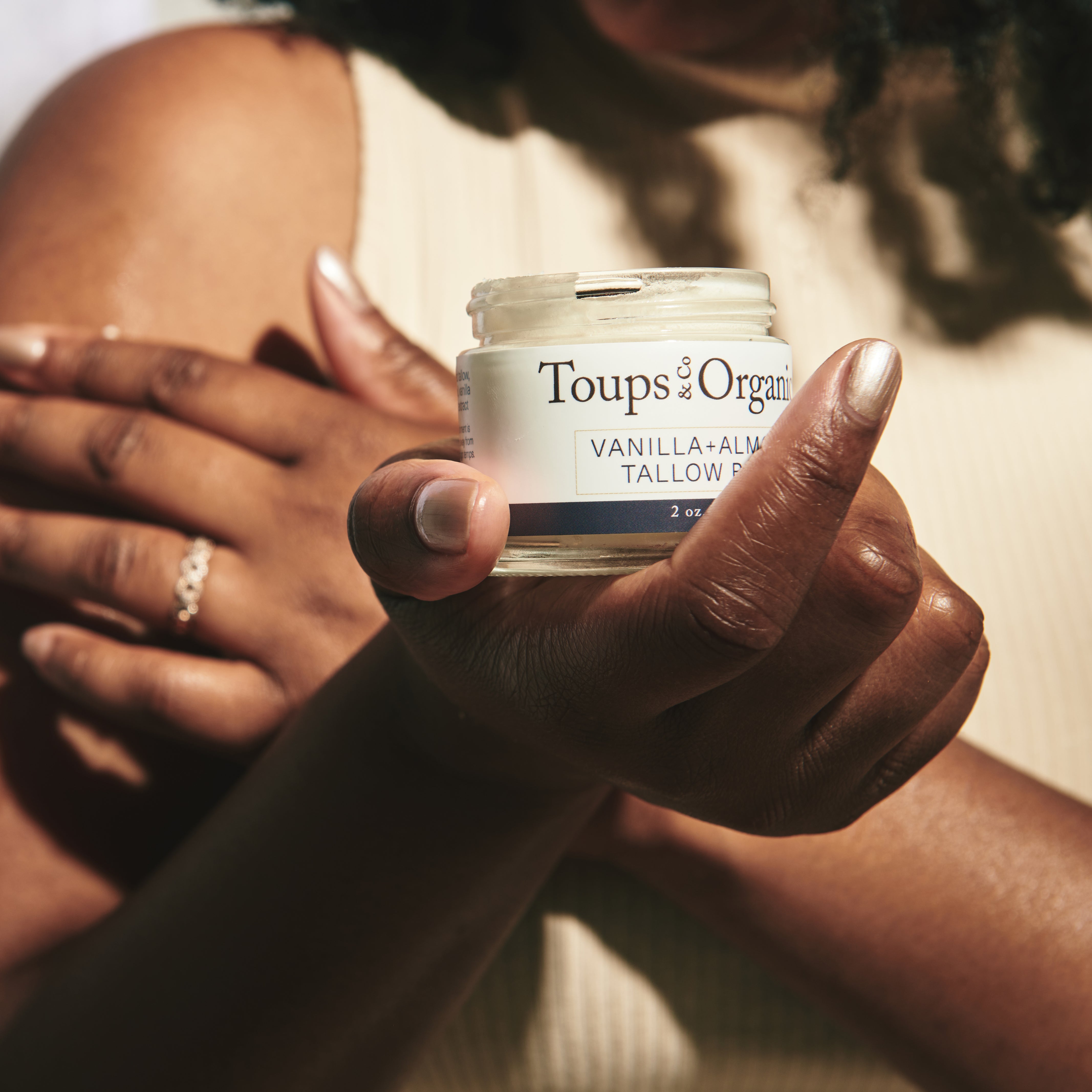 woman-holds-up-jar-of-tallow-balm