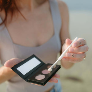 woman-dips-eyeshadow-brush-into-nontoxic-eyeshadow-palette